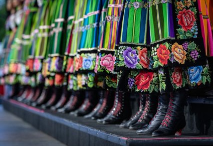 Zbliżenie na elementy damskiego kostiumu łowickiego - buty i spódnice