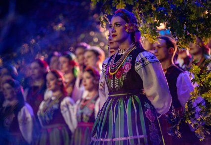 Zbliżenie na chórzystkę i elementy damskiego kostiumu łowickiego