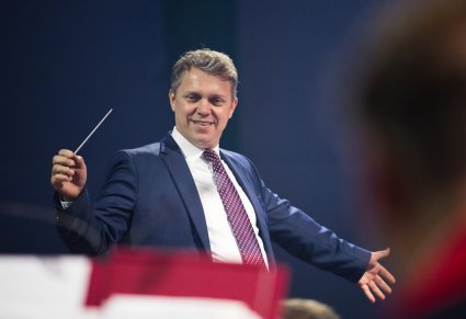 Zbliżenie na Dyrygenta trzymającego w ręku batutę