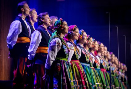 Zbliżenie na chór w kostiumach łowickich podczas koncertu