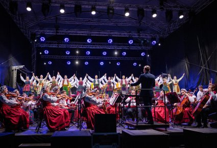 Balet w kostiumach opoczyńskich, orkiestra w kostiumach wilanowskich oraz podhalańskich, a także dyrygent  - widok z perspektywy publiczności