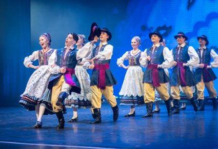 Grupa tancerzy w kostiumach kaszubskich wchodząca na scenę