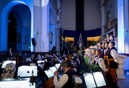 Widok boczny na Artystów Chóru w kostiumach łowickich i Orkiestrę w kostiumach wilanowskich