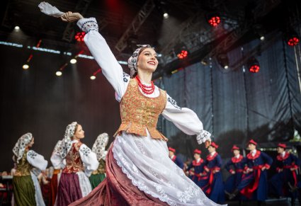 Na scenie na pierwszym planie Artystka w kostiumie wilanowskim w trakcie wykonywania choreografii tanecznej. W drugim planie reszta Artystów Baletu również w kostiumach wilanowskich