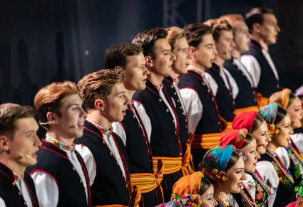 Zbliżenie na Artystów Chóru w kostiumach łowickich w trakcie śpiewu