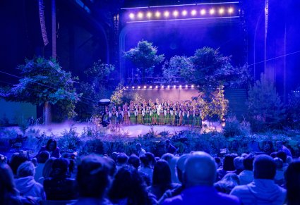 Chór w kostiumach łowickich razem z Ralphem Kamińskim na scenie festiealu, widok z perspektywy publiczności