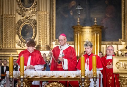Przy ołtarzu Arcybiskup wraz z ministrantami w trakcie odprawiania Mszy Świętej w Kościele Św. Krzyża w Warszawie