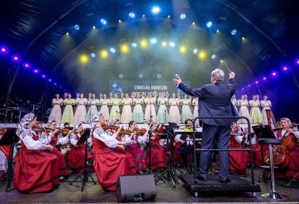 Na pierwszym planie Dyrektor Jacek Boniecki skierowany w kierunku Orkiestry i Artystów