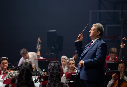 Zbliżenie na Dyrygenta trzymającego w ręku batutę