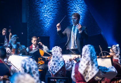 Zbliżenie na dyrygenta podczas koncertu, widoczna orkiestra