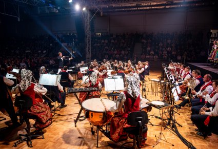 Orkiestra w kostiumach wilanowskich wraz z Dyrygentem, widoczna publiczność
