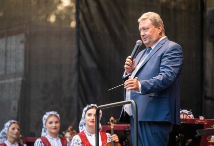 Dyrektor Jacek Boniecki na scenie w czasie wypowiedzi z widoczną orkiestrą