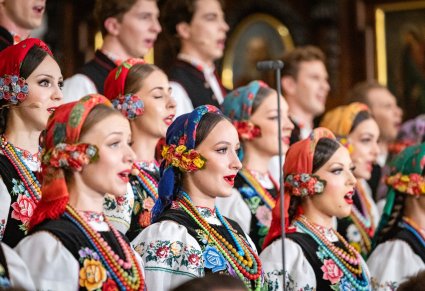 Zbliżenie na Artystów Chóru w kostiumach łowickich w trakcie śpiewu