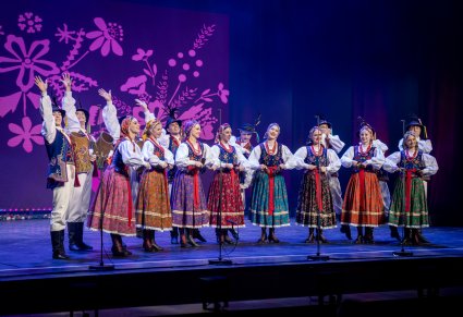 Grupa artystów w kostiumach limanowskich na scenie podczas koncertu