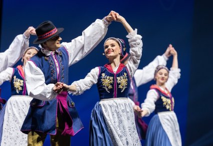 Pary Artystów w kostiumach kaszubskich w trakcie wykonywania choreografii tanecznej