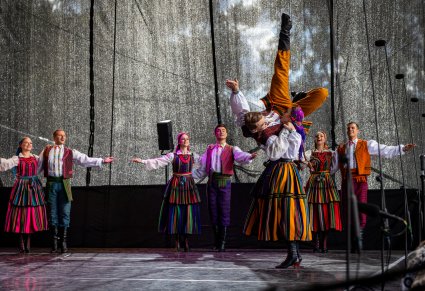 Artyści w kostiumach opoczyńskich na scenie wykonujący choreografię taneczną
