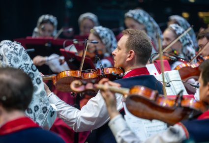 Zbliżenie na Artystów Orkiestry w kostiumach wilanowskich w trakcie grania na instrumentach smyczkowych