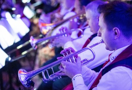 Zbliżenie na muzyków w kostiumach wilanowskich, grających na instrumentach dętych