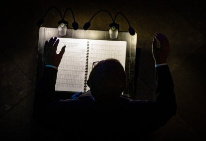 Zbliżenie od góry na ciemną postać i podświetlone nuty