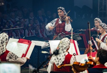 Zbliżenie na koncertmistrzynię w kostiumie wilanowskim, grającą na skrzypcach