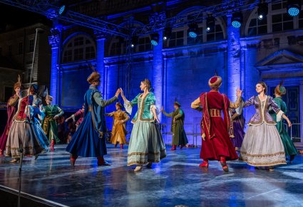 Artyści na scenie w kontuszach wykonujący choreografię taneczną