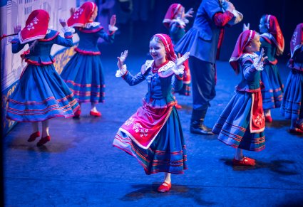 Zbliżenie na dziewczynki w kostiumach kujawskich podczas wykonywania choreografii tanecznej