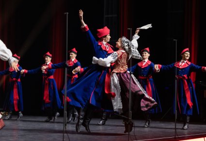Na środku sceny Para Artystów w kostiumach wilanowskich wykonująca choreografię taneczną solistyczną, widoczni również Artyści również w kostiumach wilanowskich