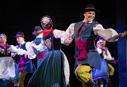 Zbliżenie na parę Artystów w kostiumach kaszubskich w trakcie wykonywania choreografii tanecznej