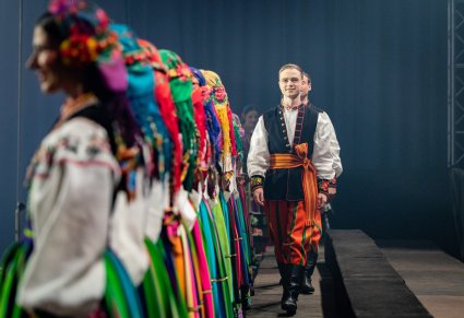Artyści Chóru w kostiumach łowickich w trakcie wchodzenia na scenę