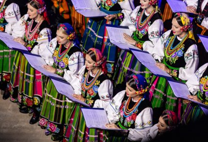 Zbliżenie na śpiewające Artystki z chóru trzymające śpiewniki