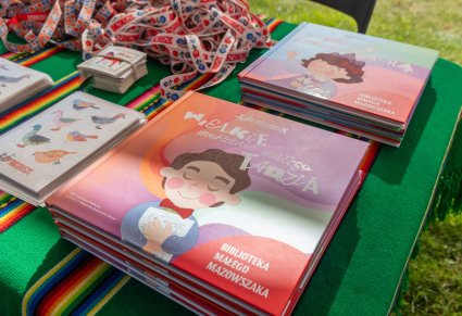 Zbliżenie na stoisko promocyjne z ulotkami i książeczkami stworzonymi przez "Mazowsze"