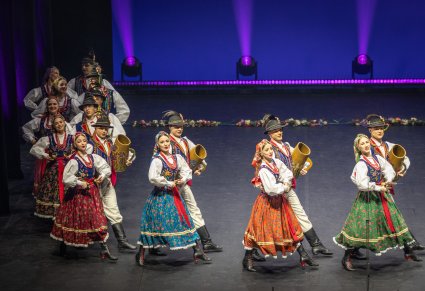 Grupa Artystów w kostiumach limanowskich podczas wspólnej choreografii na scenie