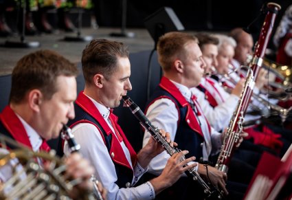 Muzycy orkiestry, w kostiumach wilanowskich, grający na instrumentach dętych