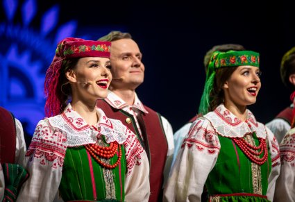 Śpiewające chórzystki w kostiumach kurpiowskich na scenie