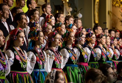 Zbliżenie na śpiewających Artystów Chóru w kostiumach łowickich