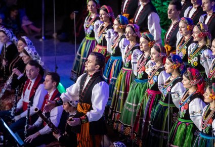 Solista chóru podczas występu na koncercie, w tle widoczny chór