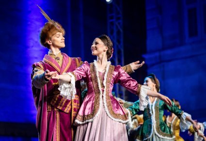 Pary Artystów w kontuszach wykonujący choreografię taneczną na scenie