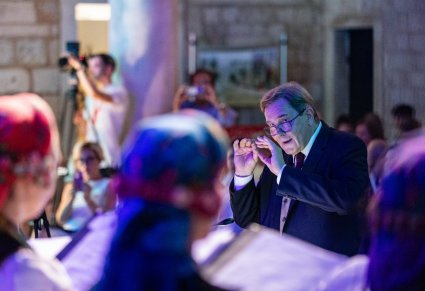 Na pierwszym planie Mirosław Ziomek zwrócony ku chórowi