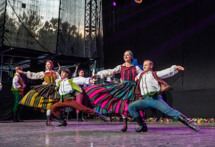Artyści w choreografii na scenie w kostiumach opoczyńskich