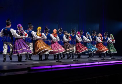Na scenie grupa Artystów w kostiumach limanowskich podczas wykonywania choreografii tanecznej