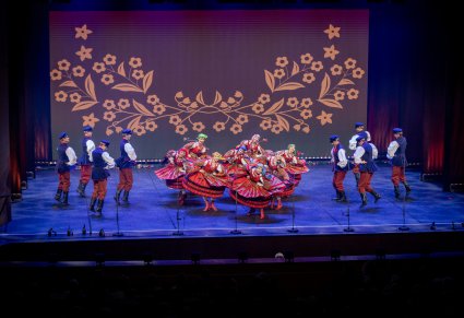 Artyści w kostiumach sieradzkich na scenie w układzie tanecznym