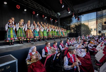 Widoczny cały chór w kostiumach łowickich, a także część orkiestry w kostiumach wilanowskich