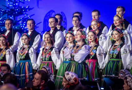 Solistka chóru podczas występu na koncercie, w tle widoczny chór