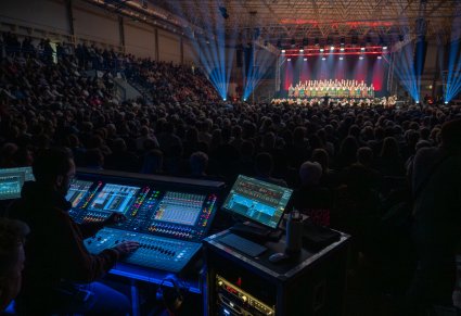 Scena z widoczną publicznością i obsługą techniczną koncertu