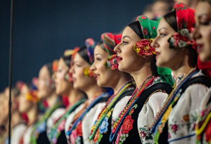 Zbliżenie na Artystki Chóru w kostiumach łowickich podczas śpiewu