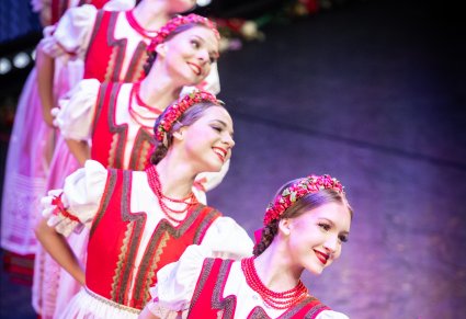 Tancerki w kostiumach jurgowskich na scenie stojace w linii