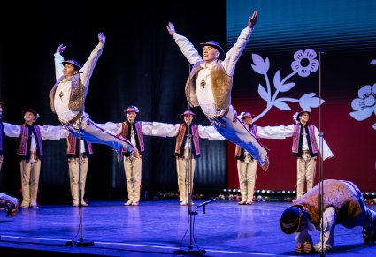 Tancerze w kostiumach jurgowskich podczas akrobacji tanecznych na scenie