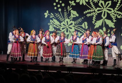 Artyści w kostiumach limanowskich wykonujący utwór na scenie