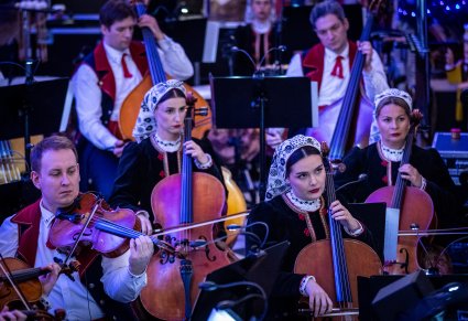 Zbliżenie na artystów orkiestry grających na instrumentach smyczkowcyh