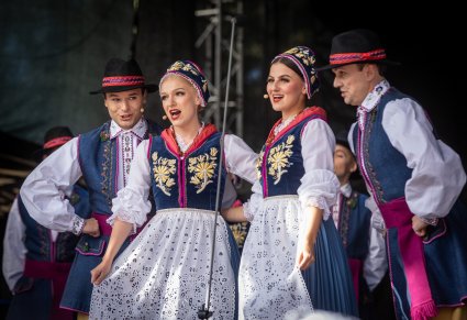 Czwórka Artystów z chóru śpiewająca na scenie w kostiumach kaszubskich